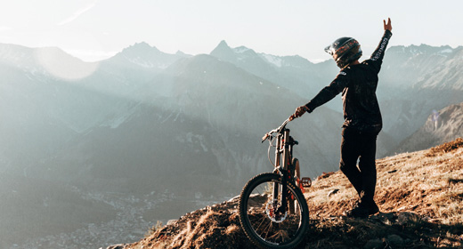 Biker al tramonto che guarda l'orizzonte dal Bikepark Mottolino a Livigno