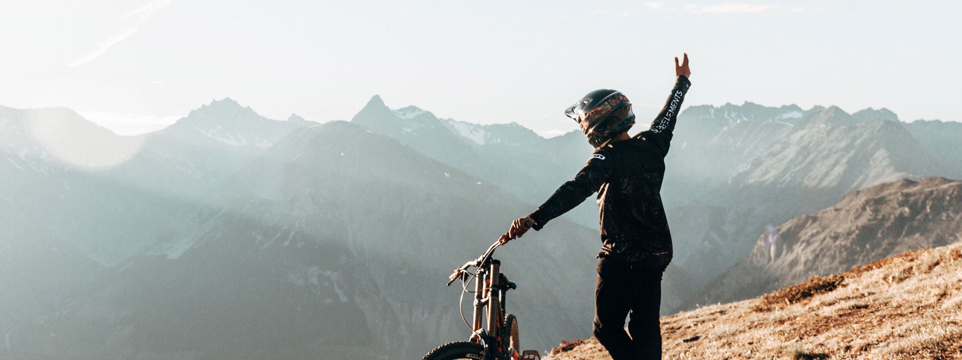 Biker al tramonto che guarda l'orizzonte dal Bikepark Mottolino a Livigno