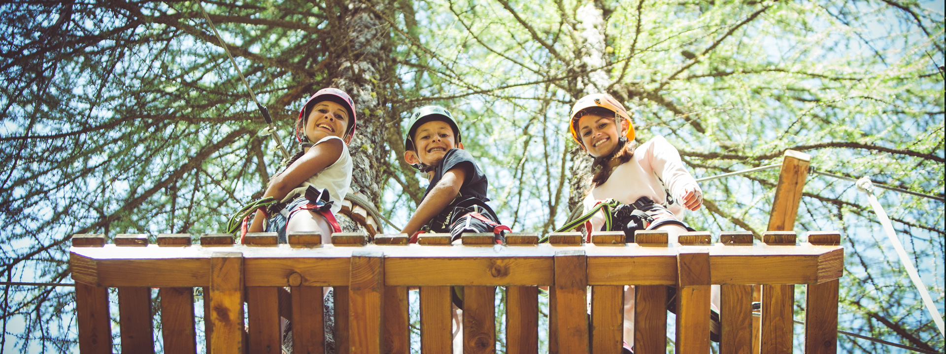 Ragazzi che si divertono sui percorsi in cima agli alberi del Larix Park a Livigno