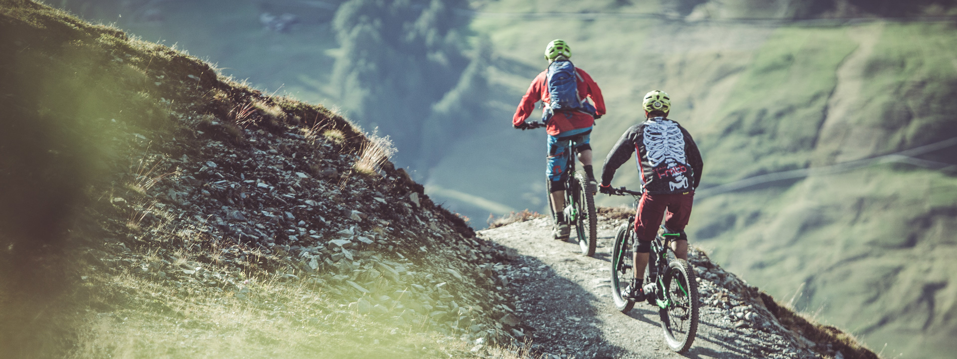 Bikers su sentiero che conduce verso l'Alpe Mine a Livigno dal Mottolino Bikepark con MTB