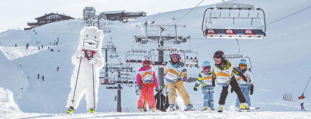 Bambini che sciano insieme a Yepi sulla pista blu della ski area Mottolino a Livigno