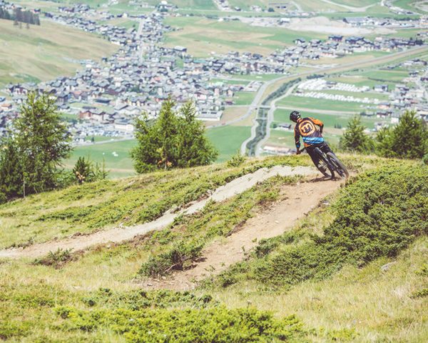 Noleggio_MTB_600x480 Biker su sentiero del versante Mottolino con bici da Enduro verso la valle di Livigno